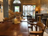 a wooden table and chairs in a room with windows at Central Old Town Cottage in Bangkok