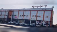 Un gran edificio con coches aparcados delante. en Fakher Yanbu Hotel, en Yanbu