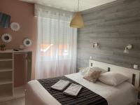 a bedroom with a bed with two towels on it at LA DAME DE COEUR in Soulac-sur-Mer