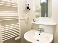 a white bathroom with a sink and a mirror at Colette Hôtel in Niort