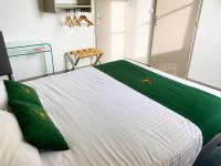a bedroom with a white bed with green pillows at Colette Hôtel in Niort
