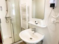 a white bathroom with a sink and a shower at Colette Hôtel in Niort