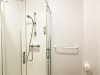 a shower with a glass door in a bathroom at Colette Hôtel in Niort