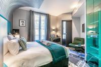 a bedroom with a large bed and a green chair at Sublim by Sweet Inn in Paris