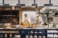 dos chefs preparando comida en una cocina comercial en The Lake House on Canandaigua, en Canandaigua