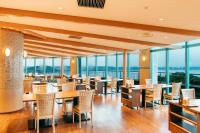 北九州市にある亀の井ホテル  玄界灘のテーブルと椅子と窓のあるレストラン