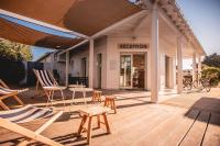 a patio with chairs and a table and a store at Le Phare in Les Portes