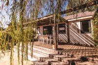 a wooden deck with a table and chairs on it at Le Phare in Les Portes