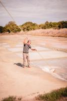 a man holding onto a rope on the beach at Le Phare in Les Portes