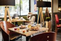 a table with plates of food on it in a restaurant at Hôtel du Musée in Granville