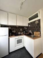 a kitchen with white cabinets and a sink at Appartement de standing calme - Paris - Métro 9 in Montreuil