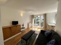 a living room with a couch and a table at Appartement de standing calme - Paris - Métro 9 in Montreuil