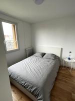 a white bedroom with a bed and a window at Appartement de standing calme - Paris - Métro 9 in Montreuil