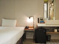 a bedroom with a bed and a desk with a lamp at Cho Hotel in Taipei