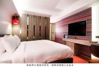 a bedroom with a large bed and a flat screen tv at Royal Hotel Group- Central Park Branch in Kaohsiung