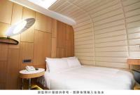 a bedroom with a bed and a phone on a table at Royal Hotel Group- Central Park Branch in Kaohsiung