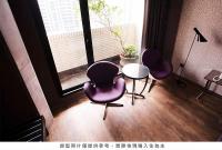 three chairs and a table in a room with a window at Royal Group Hotel Minghua Branch in Kaohsiung