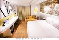 a hotel room with a bed and a chair at Royal Group Hotel Minghua Branch in Kaohsiung