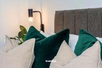 a couple of green pillows on a bed at NEW Berkley House by Truestays - 3 Bedroom House in Stoke-on-Trent in Etruria