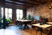 ein Restaurant mit Tischen und Stühlen und einer Backsteinmauer in der Unterkunft Hotel Hoksbergen in Amsterdam