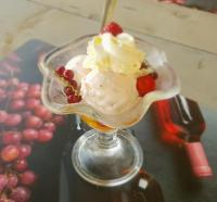 un dessert avec de la crème fouettée et des baies dans un plat en verre dans l'établissement Glamping Les Arbres, Luxe Safaritent met zwembad, à Cronat