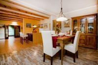 a dining room with a wooden table and white chairs at Villa Sonnhaus in Marina