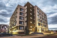 a tall building with a car parked in front of it at Fiald Hotel &amp; Spa in Bacău