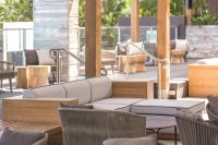 a patio with chairs and a couch and tables at Vibe Hotel Gold Coast in Gold Coast