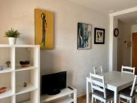 a living room with a dining room table and a television at Apartamento Gaviotas Sureñas in Tarifa