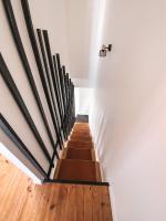 a staircase in a room with white walls and wooden floors at Gritxu Etxea in Biarritz