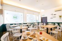 Un comedor con mesas de madera y sillas blancas. en Hotel Pacific, en Roma