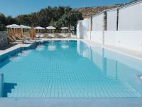 a swimming pool with blue tiles on the floor at Coralli Seaside Resort in Livadakia