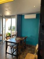 a dining room with a table and chairs and a blue wall at LE PARADIS APPARTEMENT in Martigues