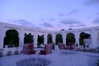 Un patio con mesas y sillas en un edificio. en Emperor Palace A Heritage villa, en Udaipur