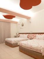 a bedroom with two beds and a ceiling with two at Happy Heart B&amp;B in Taitung City