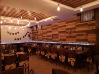 ein Festsaal mit Tischen und Stühlen und einer Holzwand in der Unterkunft Grand Monastery Private Apartments in Pamporowo