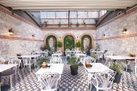 un restaurante con mesas blancas y sillas blancas en Saratoga Hotel Sultanahmet, en Estambul