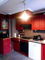 a kitchen with red cabinets and a stove top oven at Le Passe-Port pour Marseille in Marseille