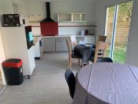 a kitchen and dining room with a table and a refrigerator at Villa Tenjin Chambre 17 in Bondy