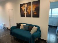 a blue couch in a room with a map on the wall at Villa Tenjin Chambre 17 in Bondy