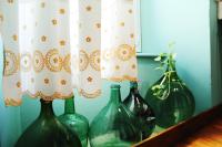 four green glass vases sitting on a shelf with curtains at Eau Berges in Vicdessos