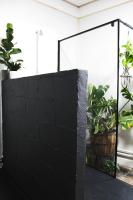 a black brick wall with plants in a room at Eau Berges in Vicdessos
