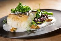 een bord eten met een stuk kip en groenten bij Elbstrand Resort Krautsand in Drochtersen