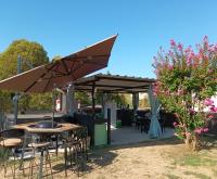 a patio with an umbrella and tables and chairs at Chambres d&#39;hôtes &amp; jacuzzi - A l&#39;ombre des amandiers in Saint-Martin-dʼArdèche
