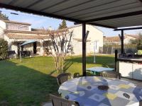 a patio with a table and chairs in a yard at Chambres d&#39;hôtes &amp; jacuzzi - A l&#39;ombre des amandiers in Saint-Martin-dʼArdèche