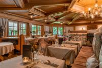 a dining room with tables and chairs and chandeliers at Ferienhotel Sonnenhof in Zell am Ziller