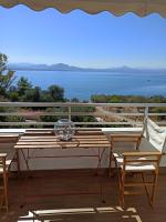 Una mesa y sillas en un balcón con vista al mar. en Atlas Endless Blue Apartment, en Loutraki