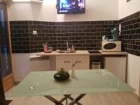 a kitchen with a table with a sink and a tv at Le Betrot in Estissac