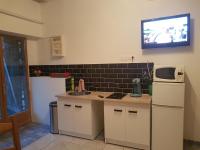 a kitchen with a sink and a tv on the wall at Le Betrot in Estissac