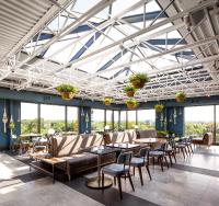 a dining room with tables and chairs and windows at The Broadview Hotel in Toronto